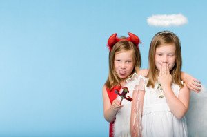 Twin girls dressed as an angel and devil